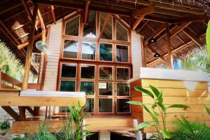 Casa de madera con ventana grande en Hygge Siargao, en General Luna