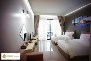 Namthong Nan Hotel في نان: غرفه فندقيه سريرين وتلفزيون