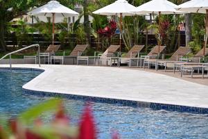 a swimming pool with chairs and umbrellas next to a pool at Art Hotel Ishigakijima in Ishigaki Island