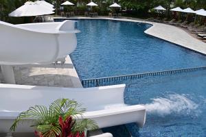 a swimming pool with a white bench in a resort at Art Hotel Ishigakijima in Ishigaki Island