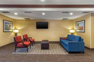 une salle d'attente avec un canapé bleu et des chaises dans l'établissement Comfort Suites McKinney-Allen, à McKinney
