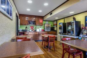 a kitchen with wooden cabinets and tables and chairs at Econo Lodge in Nashville
