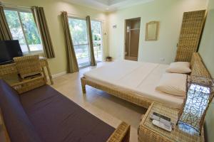 a bedroom with a bed and a tv and a chair at Mike's Dauin Dive Resort in Dauin