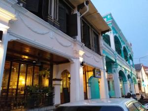 a car parked in front of a building at Phuket Sunny Hostel in Phuket Town