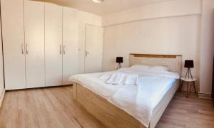 um quarto com uma cama grande e armários brancos em Mountain Residence em Brasov