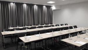 una sala de conferencias con mesas, sillas y cortinas en Hotel Colors Inn, en Sarajevo