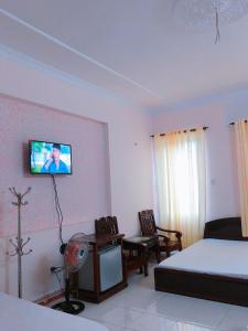 1 dormitorio con 1 cama y TV en la pared en Quang Diep Motel, en Vung Tau