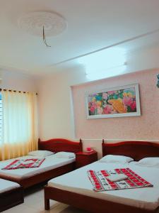 Habitación con 2 camas y una pintura en la pared. en Quang Diep Motel, en Vung Tau
