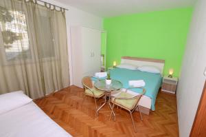 a room with a bed and a table and chairs at Apartments Vodanović in Podgora