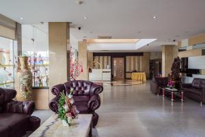 een lobby met leren banken en een tafel in een gebouw bij Aviari Hotel in Sekupang