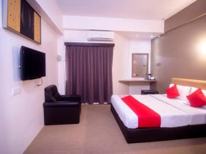 a hotel room with a bed and a chair at Super OYO 979 Hua Kuok Inn in Kuching