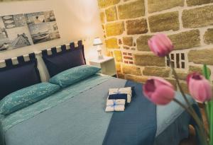 een slaapkamer met een blauw bed met roze bloemen bij La casetta in Terrasini