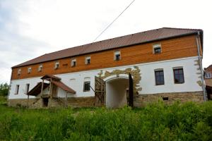 een groot wit gebouw met een bruin dak bij Penzion Květná Zahrada in Květná