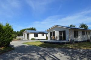 a white house with a porch and a driveway at Woodbyne Resort in Cowes