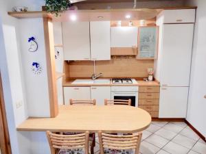 una pequeña cocina con mesa de madera y sillas en Appartamento Le Mimose, en Viareggio
