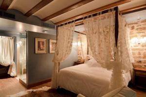 a bedroom with a canopy bed with white curtains at Hospederia de los Parajes in Laguardia
