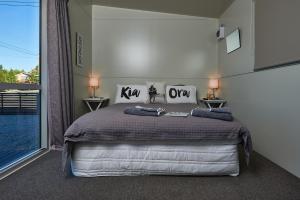 ein Schlafzimmer mit einem Bett und einem großen Fenster in der Unterkunft WanaHaka - Lake Wanaka & Town at your door in Wanaka