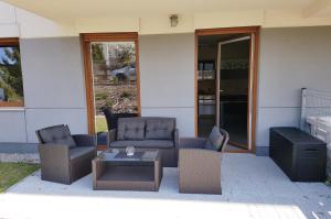 a patio with two couches and a coffee table at Nowoczesny Apartament w Centrum in Kościerzyna
