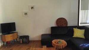 ein Wohnzimmer mit einem schwarzen Sofa und einem Tisch in der Unterkunft Haus Liebevoll in Wald 102 in Gunzenhausen