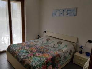 a bedroom with a bed with a colorful quilt on it at Casa Lella with pool and garden in Lenno