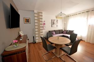 een woonkamer met een tafel en een bank bij Apartment Simoni ZD in Zadar