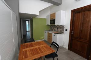 a small kitchen with a wooden table and chairs at Timpa rooms in Pizzo