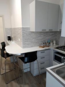 a kitchen with white cabinets and a table and chairs at ARNO ROOMS VERONA in Verona