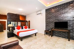 a hotel room with a bed and a tv at Baan Noppadol Hua Hin Loft in Hua Hin