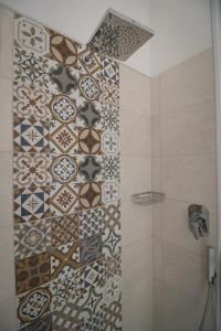 a bathroom with a shower with a tiled wall at Civico 1 in San Mauro Cilento +14 photos