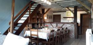 a dining room with a table with chairs and a staircase at La Belle Vue in Roy