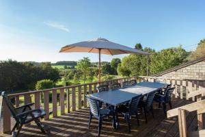 a table and chairs and an umbrella on a deck at La Belle Vue in Roy