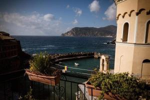 a building with a swimming pool next to the ocean at Camere Nicolina in Vernazza