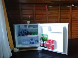 an open refrigerator filled with soda and water at Ginanthi Cottage in Nusa Penida