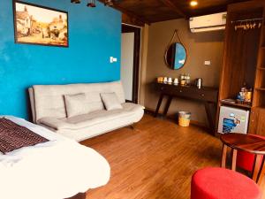 サパにあるYouth Homestay Sapaのベッドとソファとテーブルのある部屋