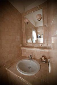 uma casa de banho com um lavatório e um espelho em Camere Nicolina em Vernazza