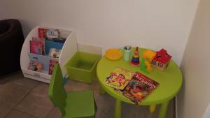 a small green table with books and toys on it at Résidence Thalacap in Cap d'Agde