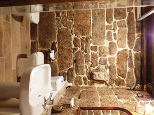 pared de piedra en el baño con lavabo en Pazo de Turbisquedo, en Turbisquedo