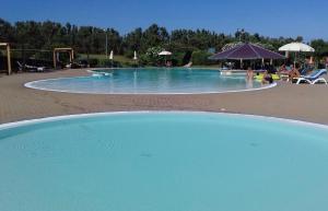 a large pool with blue water in a resort at Residence Hotel Monte Ricciu Nuova Gestione in Alghero