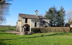 stary kamienny kościół na polu trawy w obiekcie Logis des Voyageurs w mieście Pont-de-Salars