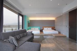 1 dormitorio y sala de estar con 1 cama y 1 sofá. en Yuansu.MHL48 B&B, en Dongshan