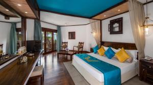um quarto com uma cama, uma secretária e uma televisão em Royal Palms Beach Hotel em Kalutara