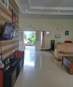 uma grande sala de estar com um sofá e uma televisão em Pildacil em Garut