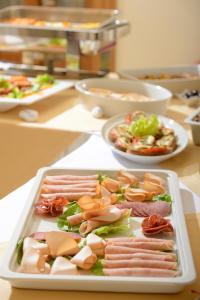 a tray of meats and vegetables on a table at Tamarix Del Mar Suites in Kamari