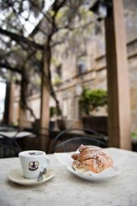 un plato de repostería y una taza de café sobre una mesa en Giamevi House, en Vignanello