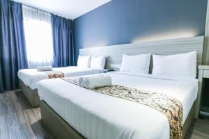two beds in a hotel room with blue walls at Hotel 99 Kepong in Kuala Lumpur