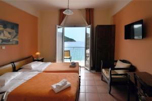 a hotel room with two beds and a balcony at Golden View in Poros