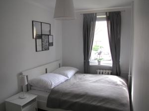 a small bedroom with a bed and a window at Apartament Okrzei in Kłodzko