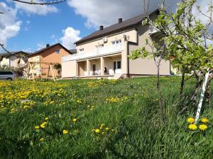 ein Feld gelber Blumen vor einem Haus in der Unterkunft Apartment and Rooms Aračić in Korenica