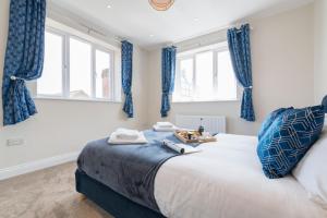 South Quay Penthouse - 2 Bed في غريت يورماوث: غرفة نوم بسرير كبير مع ستائر زرقاء