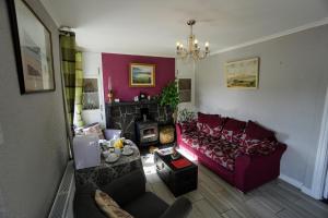 a living room with a red couch and a fireplace at Kings Accommodation in Donegal